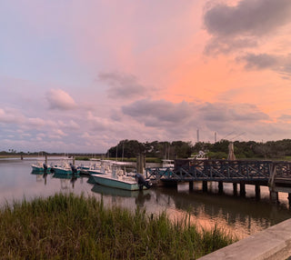 Marina photo with boats under a colorful pink and purple evening sunset sky